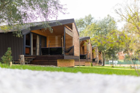 Chalets en bois au Halicanum Glamping Peaceful Retreat Resort 3 en Croatie, entourés de verdure et d’arbres paisibles.