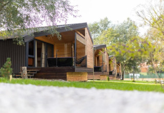 Chalets en bois au Halicanum Glamping Peaceful Retreat Resort 3 en Croatie, entourés de verdure et d’arbres paisibles.