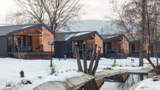 Halicanum Glamping Peaceful Retreat Resort 16 chalets in een besneeuwd landschap met bomen en een beekje.