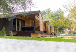 Chalets en bois avec terrasse au Halicanum Glamping Peaceful Retreat Resort 16, entourés de verdure en Croatie.