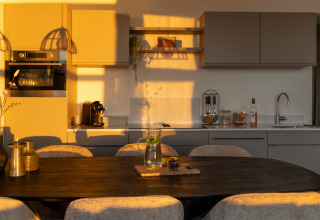 Moderne keuken en eetruimte in warm zonlicht bij MarinaPark Beach Resort Soal, Friesland, Nederland.