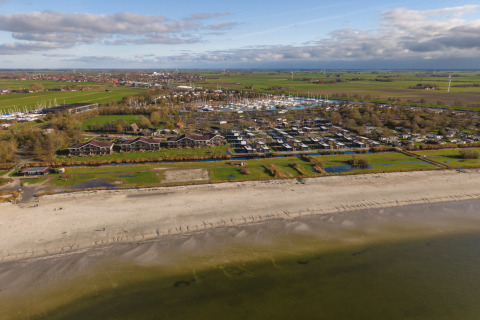 Vue aérienne de MarinaPark Beach Resort Soal en Frise, Pays-Bas, montrant plage, marina et logements.
