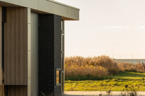 Modernes Ferienhaus im MarinaPark Beach Resort Soal in Friesland, Niederlande, mit Blick auf Felder.