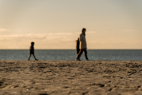 Silhouettes de personnes marchant sur le sable à MarinaPark Beach Resort Soal, en Frise, aux Pays-Bas.