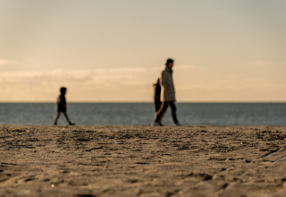 Silhouetten van mensen wandelend op het strand bij MarinaPark Beach Resort Soal in Friesland, Nederland.