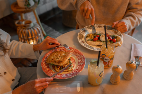 Two people enjoy a delicious meal with sandwiches and drinks at MarinaPark Beach Resort Soal.