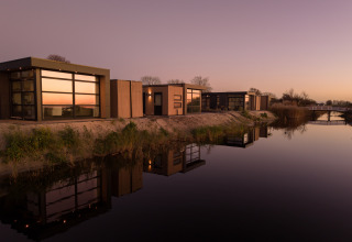 Cabanes de vacances modernes au bord de l'eau à MarinaPark Beach Resort Soal, Friesland, Pays-Bas, au coucher du soleil.