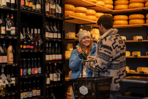 Due persone fanno acquisti di vino e formaggio al MarinaPark Beach Resort Soal in Frisia, Paesi Bassi.