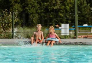 Two children sit by the edge of a pool at MarinaPark Residentie Bloemendaal, North Holland, Netherlands.