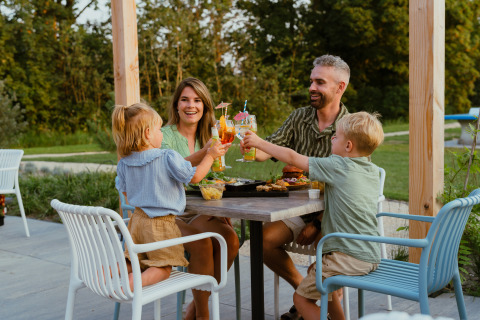 Famiglia che brinda e si gode un pasto all’aperto a MarinaPark Residentie, Bloemendaal, Paesi Bassi.