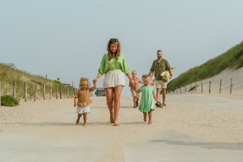 Familie nyder en solrig dag ved stranden i MarinaPark Residentie Bloemendaal, Nordholland, Holland.
