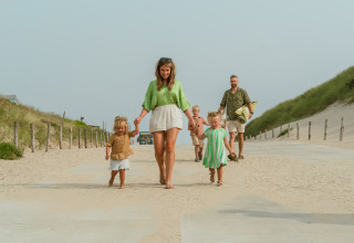 Family walking on a beach path at MarinaPark Residentie Bloemendaal holiday park, North-Holland, Netherlands.
