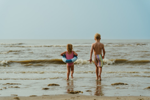 Two children playing at the water’s edge at MarinaPark Residentie Bloemendaal beach in North Holland.
