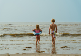Two children playing at the water’s edge at MarinaPark Residentie Bloemendaal beach in North Holland.