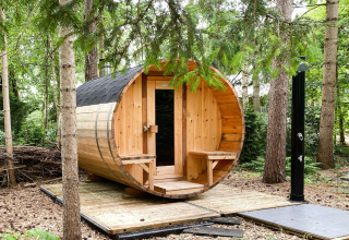 Een tonvormige houten buitensauna op een platform in het bos bij Dutch Cabin Houses C66 in Nederland