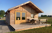 Houten lodge met terras en tuinbank aan «Frisian Hideaway with Style» in Nederland.