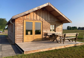 Houten lodge met terras en tuinbank aan «Frisian Hideaway with Style» in Nederland.