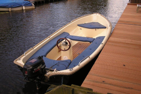 Petite embarcation à moteur amarrée à un quai en bois près du Luxury chalet 55 aux Pays-Bas.