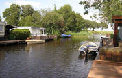 Blick auf einen Kanal mit Booten und Hausbooten bei Luxury chalet 55 in den Niederlanden.