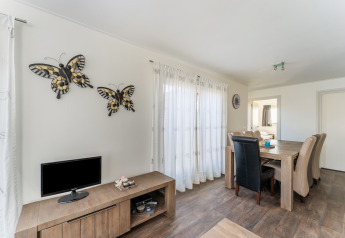 Lyst spisestueområde i en husbåd, med træmøbler, dekoreret med sommerfugle på væggen, Holland.