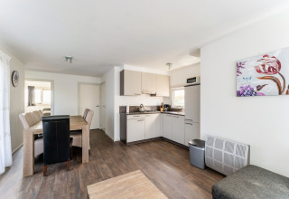 Moderne open keuken en eetkamer op woonboot Luxury chalet 55 in Nederland met houten vloer
