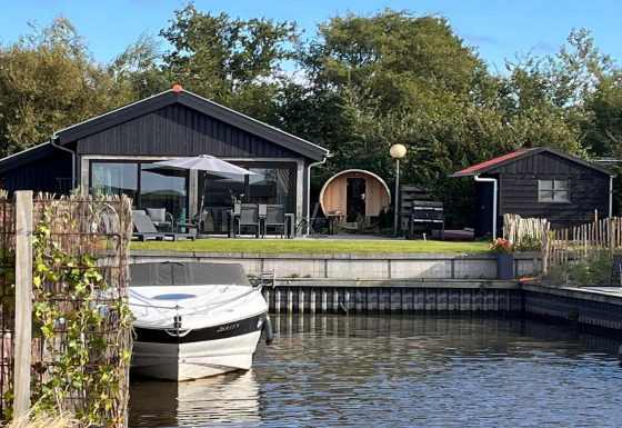 Ferielodge ved vandet med terrasse, båd, sauna og grøn have, kaldet Scenic Stay with Sauna.