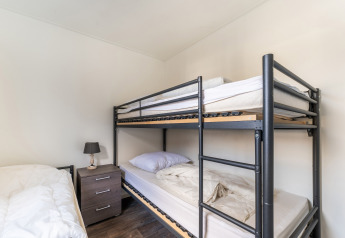 Camera da letto nella houseboat Luxury chalet 55 nei Paesi Bassi con letto a castello e comodino.