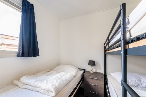 Schlafzimmer im Hausboot Luxury chalet 55 in den Niederlanden mit Etagenbett, Einzelbett und Fenster.