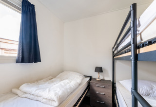 Camera da letto su houseboat Luxury chalet 55 nei Paesi Bassi con letto a castello, letto singolo e finestra.