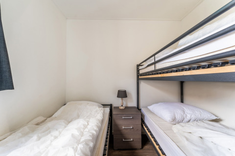 Schlafzimmer im Hausboot Luxury chalet 55 in den Niederlanden mit Einzelbett, Etagenbett und Nachttisch.