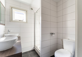 Baño moderno con lavabo doble, inodoro y ducha en una lujosa casa flotante en los Países Bajos.