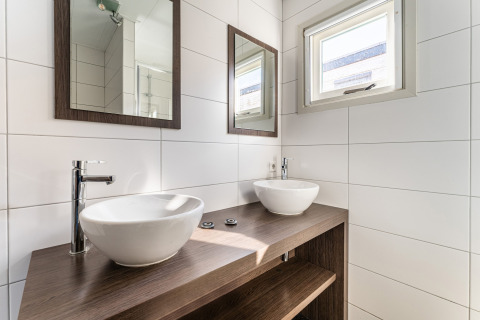 Modernes Badezimmer mit zwei Waschbecken, Spiegeln und Fenster auf einem Luxus-Hausboot in den Niederlanden.