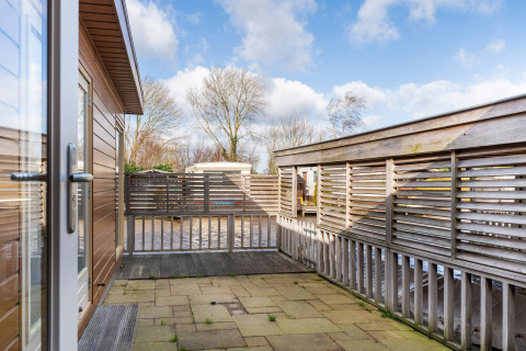 Udsigt fra terrassen på Luxury chalet 55 husbåd i Holland med moderne hegn og blå himmel.
