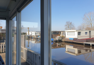 Vista dalla finestra di una houseboat al Luxury chalet «54 Bantega» con acqua nei Paesi Bassi.