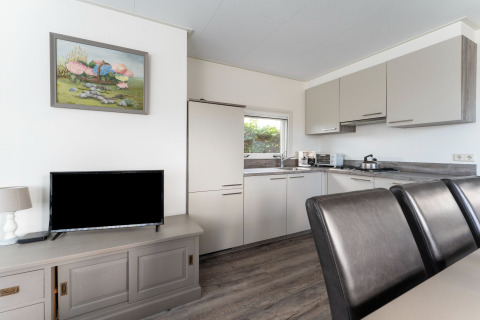Moderne Küche und Essbereich im Hausboot Luxury chalet «54 Bantega» in den Niederlanden mit TV.