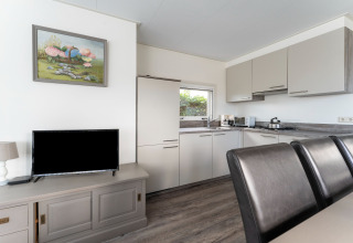 Cucina moderna e zona pranzo sul houseboat Luxury chalet «54 Bantega» nei Paesi Bassi, con televisore.