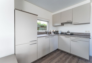 Moderne keuken op het woonboot Luxury chalet «54 Bantega» in Nederland met grijze kasten.