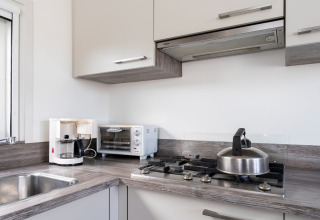 Modern houseboat kitchen corner with coffee maker, toaster oven, gas stove, and kettle in the Netherlands.