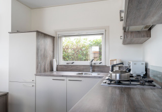 Modernes Hausboot-Küche im Luxury chalet '54 Bantega' in den Niederlanden, mit Gasherd und Fenster.
