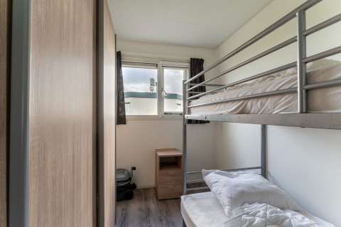 Kamer met stapelbed, nachtkastje en raam op de luxe woonboot 54 Bantega in Nederland.