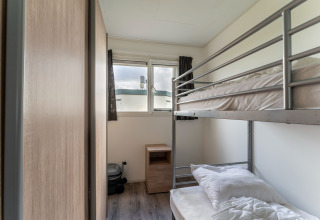 Camera con letto a castello, comodino e finestra sulla casa galleggiante di lusso 54 Bantega, Paesi Bassi.