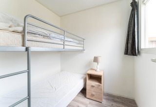 Bright bedroom on houseboat Luxury chalet «54 Bantega» in the Netherlands with bunk bed and window.