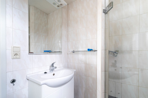 Moderne badkamer met wastafel, spiegel en douche op woonboot Luxury chalet «54 Bantega» in Nederland.