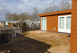 Cortile soleggiato presso Luxury chalet 54 Bantega, con vista su houseboat e alberi nei Paesi Bassi.