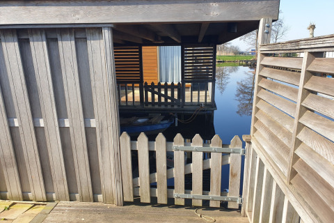Cancello e recinzione in legno che conducono alla terrazza galleggiante del Luxury chalet «54 Bantega» nei Paesi Bassi.