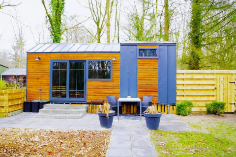Charming Tiny House en los Países Bajos, con exterior moderno de madera y metal y terraza al aire libre.