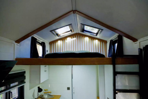 Dormitorio tipo loft en una tiny house encantadora con tragaluces, escalera e interior moderno en Holanda.