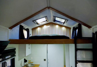 Dormitorio tipo loft en una tiny house encantadora con tragaluces, escalera e interior moderno en Holanda.