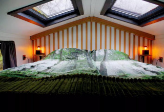 Acogedor altillo de dormitorio en el Charming Tiny House en Países Bajos, con claraboyas y luces tenues.