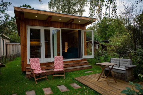 Encantador chalet de madera en Sint Maartenszee, Países Bajos, con terraza y muebles de jardín cómodos.